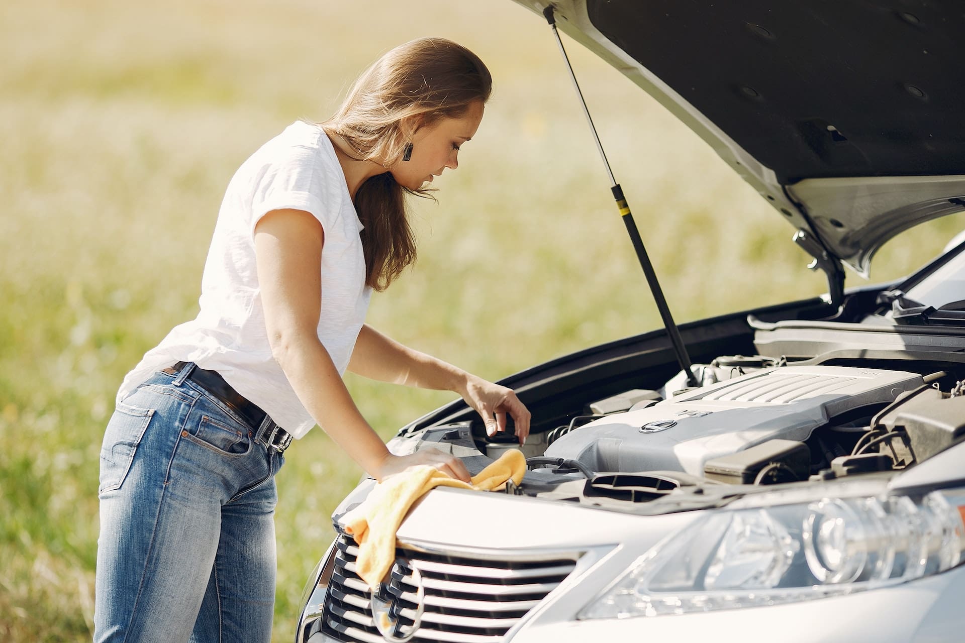 woman next to her broken car thinking about her next steps with the lemon law