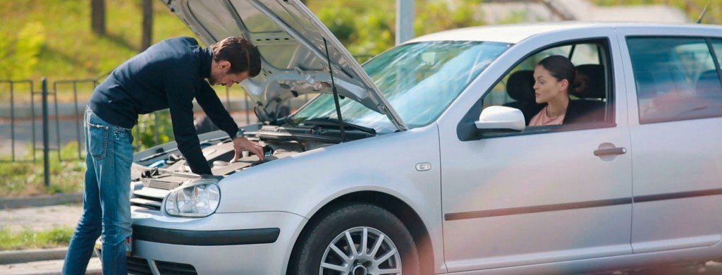 man checking his used car for problems